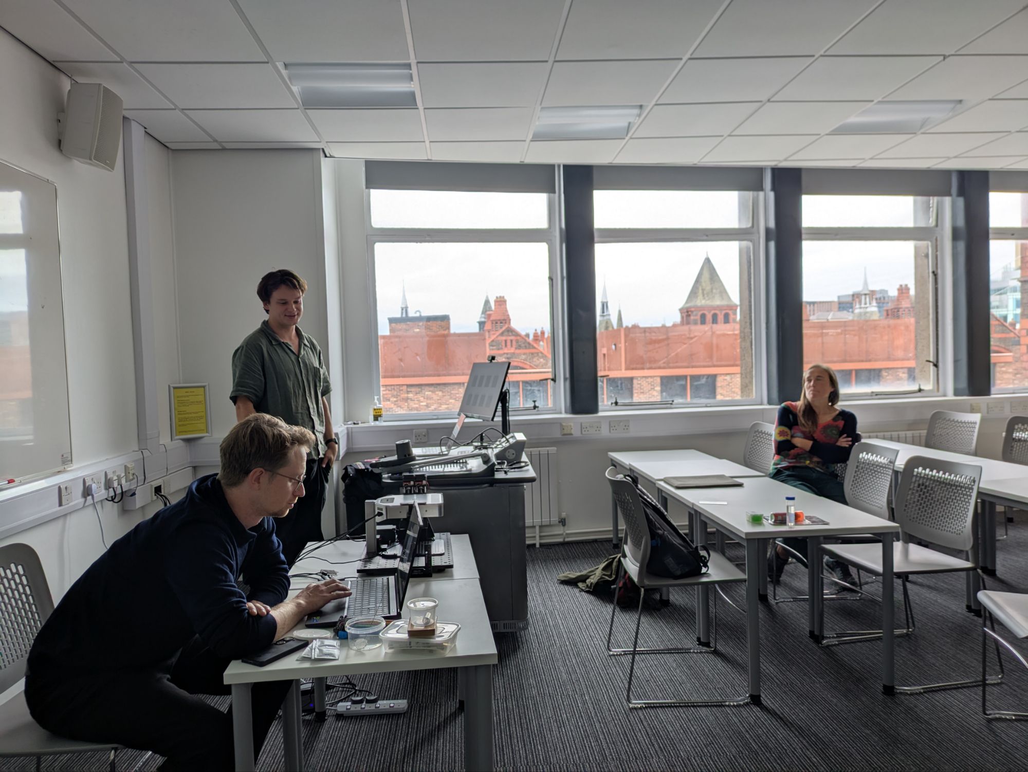 AcoustoFab visit to UoL - three people in shot around a ultrasonic levitation platform.